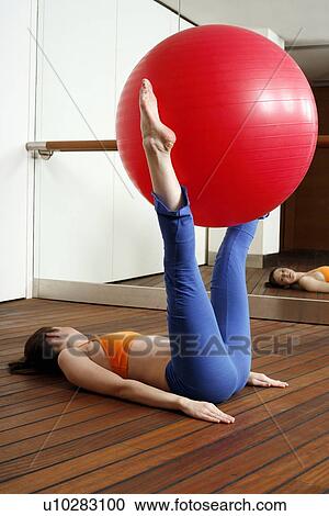 Stock Image - Young woman performing a pilates exercise. Fotosearch