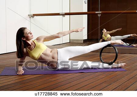 Young woman performing a pilates exercise View Large Photo Image Stock Photography - Young woman performing a pilates exercise. Fotosearch