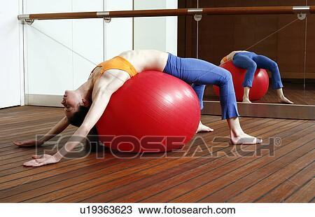 Young woman performing a pilates stretch View Large Photo Image Stock Image - Young woman performing a pilates stretch. Fotosearch