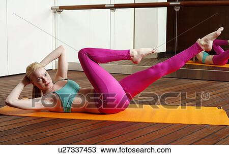 Stock Image - Young woman performing a pilates stretch. Fotosearch