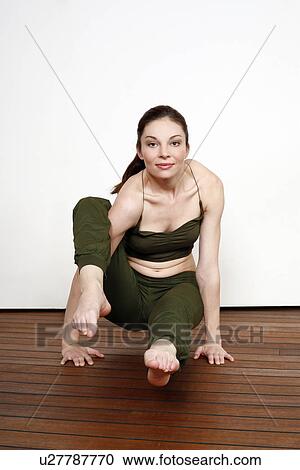 Stock Image - Young woman performing a pilates stretch. Fotosearch