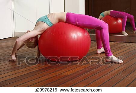 Stock Photograph - Young woman performing a pilates stretch. Fotosearch