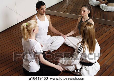 Participants in a fitness class meditating View Large Photo Image Stock Image - Participants in a fitness class meditating. Fotosearch