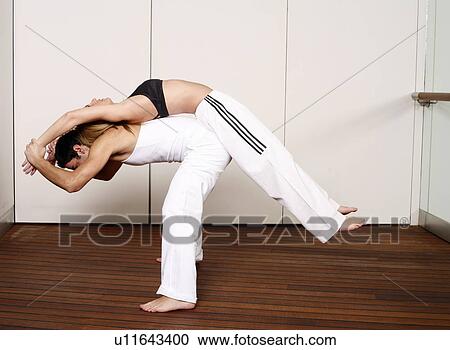 Partners practicing flexibility in yoga and Capoeira programs View Large Photo Image Stock Image - Partners practicing flexibility in yoga and Capoeira programs. Fotosearch