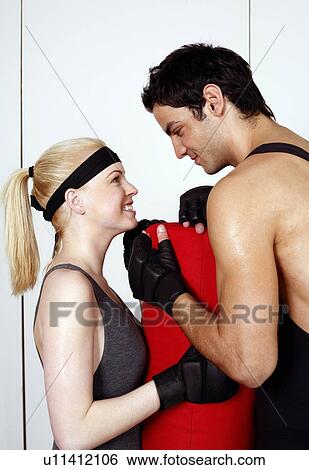 Stock Photograph - Young man and woman flirting in a fitness class. Fotosearch
