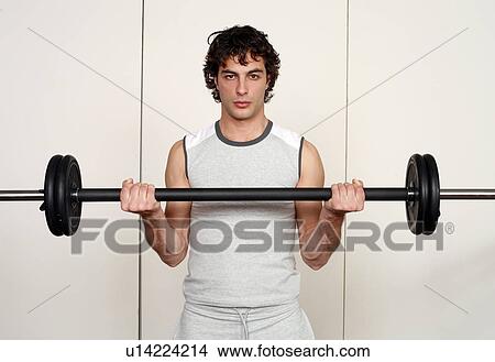 Young man lifting weights View Large Photo Image Picture - Young man lifting weights. Fotosearch