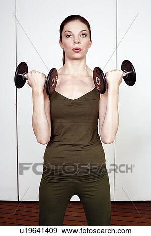 Stock Photo - Young woman lifting weights. Fotosearch