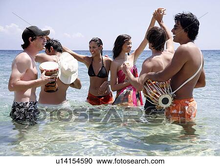Stock Image - Group of friends in water having fun. Fotosearch