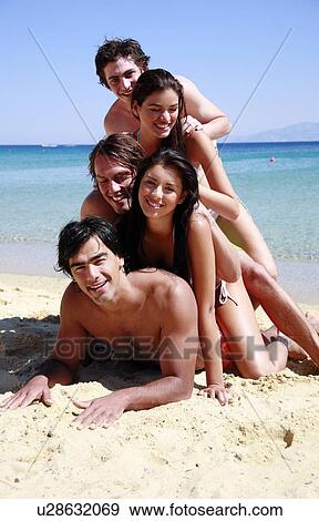 Stock Photo - Group of friends piling into a pyramid. Fotosearch
