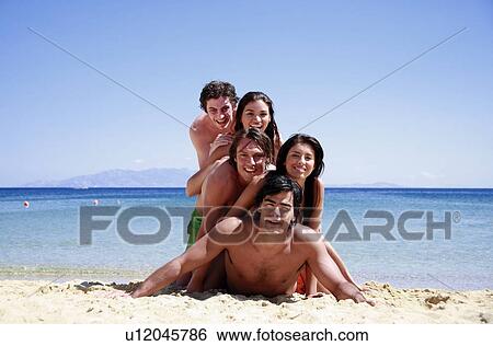 Stock Photograph - Group of friends piling into a pyramid. Fotosearch