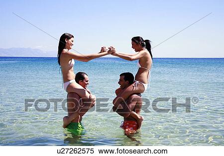 Stock Photography - Group of friends playing in the water. Fotosearch