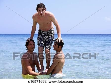 Three young men playing in the water View Large Photo Image Stock Image - Three young men playing in the water. Fotosearch