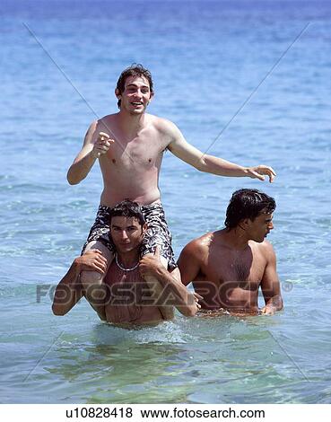 Stock Photo - Three young men playing in the water. Fotosearch
