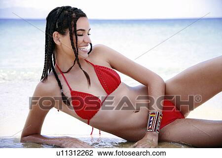 Stock Image - Young woman in bikini on beach. Fotosearch