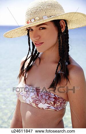 Young woman with bikini and hat posing on the beach View Large Photo Image Stock Photo - Young woman with bikini and hat posing on the beach. Fotosearch
