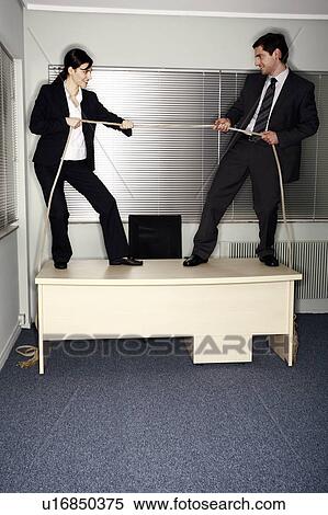 Stock Photography - Male and female business people pulling ends of rope. Fotosearch
