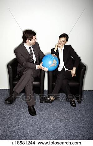 Male and female businesspeople with globe View Large Photo Image Picture - Male and female businesspeople with globe. Fotosearch