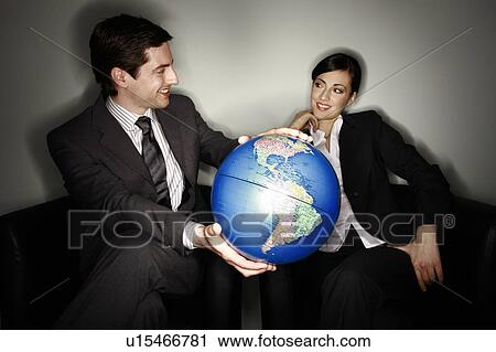 Male and female businesspeople with globe View Large Photo Image Stock Image - Male and female businesspeople with globe. Fotosearch
