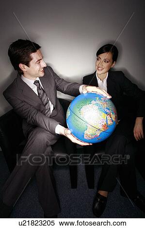 Stock Photography - Male and female businesspeople with globe. Fotosearch
