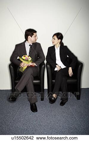Male office worker with flowers sitting next to female colleague View Large Photo Image Stock Image - Male office worker with flowers sitting next to female colleague. Fotosearch