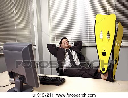 Office worker at computer wearing swim flippers View Large Photo Image Stock Image - Office worker at computer wearing swim flippers. Fotosearch