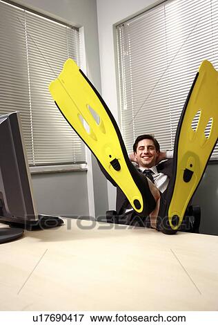 Office worker at computer wearing swim flippers View Large Photo Image Stock Photo - Office worker at computer wearing swim flippers. Fotosearch