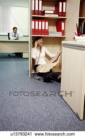 Office worker on the phone hiding from manager View Large Photo Image Stock Image - Office worker on the phone hiding from manager. Fotosearch