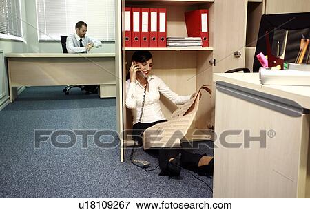 Office worker on the phone hiding from manager View Large Photo Image Stock Photo - Office worker on the phone hiding from manager. Fotosearch