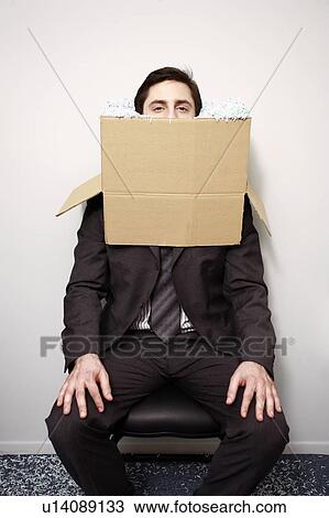 Stock Image - Office worker with head in a box. Fotosearch