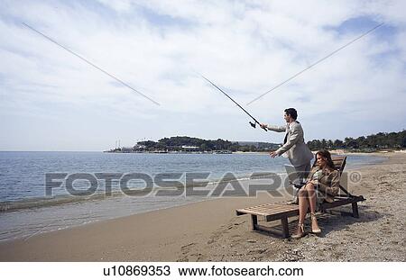 Business couple on beach with fishing rod and laptop View Large Photo Image Stock Image - Business couple on beach with fishing rod and laptop. Fotosearch