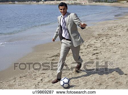 Businessman on beach playing soccer View Large Photo Image Stock Photo - Businessman on beach playing soccer. Fotosearch