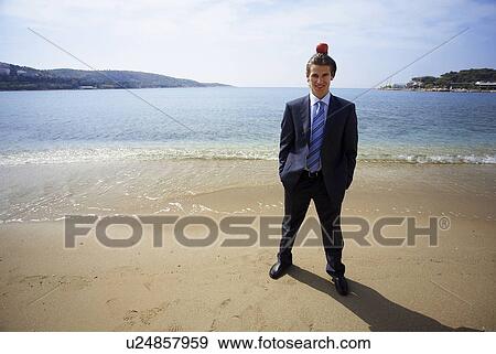 Stock Photo - Businessman on beach with apple balanced on his head. Fotosearch