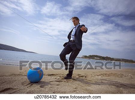 Businessman on beach with globe beach ball View Large Photo Image Stock Image - Businessman on beach with globe beach ball. Fotosearch