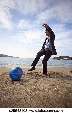 Businessman on beach with globe beach ball View Large Photo Image Stock Image - Businessman on beach with globe beach ball. Fotosearch