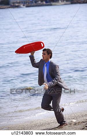 Businessman on beach with life preserver View Large Photo Image Stock Image - Businessman on beach with life preserver. Fotosearch