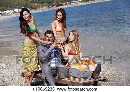 Businessman on beach with three women View Large Photo Image Stock Image - Businessman on beach with three women. Fotosearch