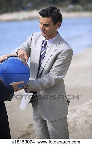 Businessmen hands grasping the globe View Large Photo Image Picture - Businessmen hands grasping the globe. Fotosearch
