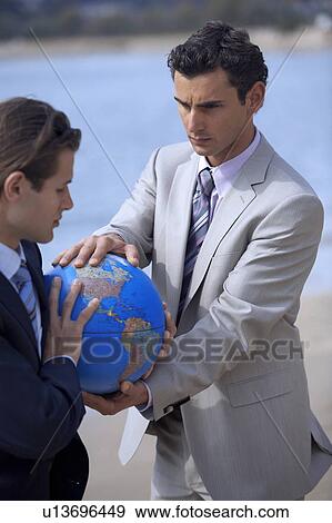 Businessmen hands grasping the globe View Large Photo Image Stock Photo - Businessmen hands grasping the globe. Fotosearch