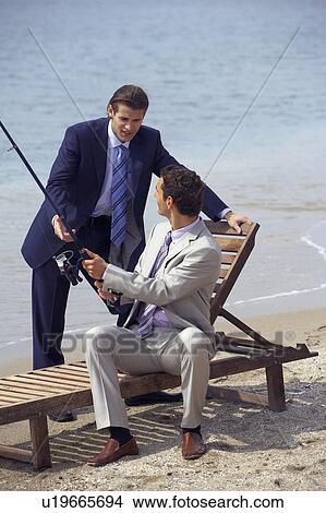 Picture - Businessmen on beach fishing. Fotosearch