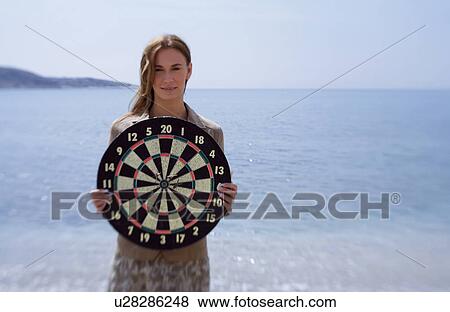Businesswoman on beach with dartboard View Large Photo Image Stock Photo - Businesswoman on beach with dartboard. Fotosearch