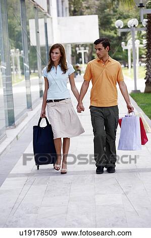 Stock Photo - Couple walking with shopping bags. Fotosearch
