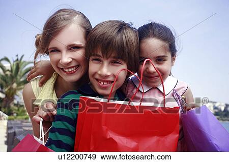 Mother and two children with shopping bags View Large Photo Image Stock Photo - Mother and two children with shopping bags. Fotosearch