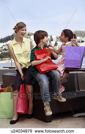Mother and two children with shopping bags View Large Photo Image Stock Photo - Mother and two children with shopping bags. Fotosearch