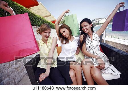 Three women with shopping bags posing View Large Photo Image Stock Image - Three women with shopping bags posing. Fotosearch