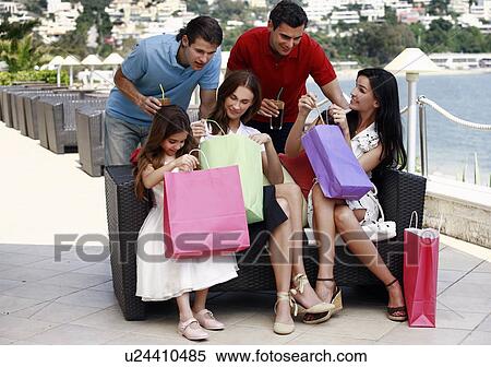 Stock Photography - Two couples and child with shopping bags. Fotosearch