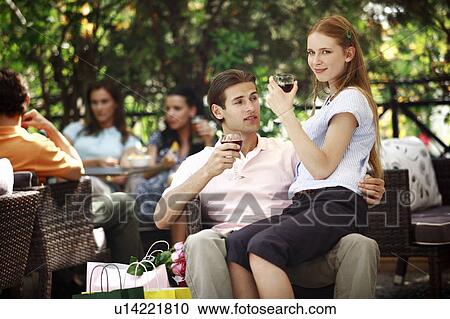 Woman sitting on man's lap with shopping bags in cafe View Large Photo Image Stock Image - Woman sitting on man's lap with shopping bags in cafe. Fotosearch