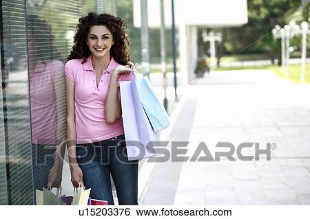 Woman with shopping bags in front of store window View Large Photo Image Stock Photograph - Woman with shopping bags in front of store window. Fotosearch
