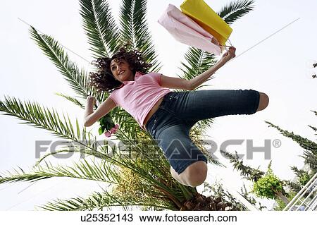 Woman with shopping bags jumping View Large Photo Image Stock Image - Woman with shopping bags jumping. Fotosearch