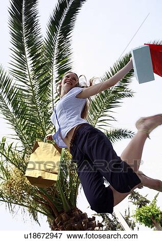 Woman with shopping bags jumping View Large Photo Image Stock Photo - Woman with shopping bags jumping. Fotosearch