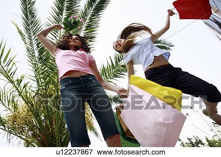 Women with shopping bags jumping View Large Photo Image Stock Photo - Women with shopping bags jumping. Fotosearch